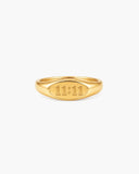 Polished gold-tone signet ring engraved with “11:11” on a white background.