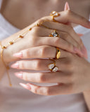 11:11 engraved ring styled with layered gold jewelry and pale pink nails.