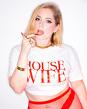 Model wearing the white House Wife cropped tee with bold red lettering.