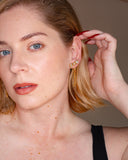 Ariadne chain tassel earring worn at the ear in a close-up portrait.