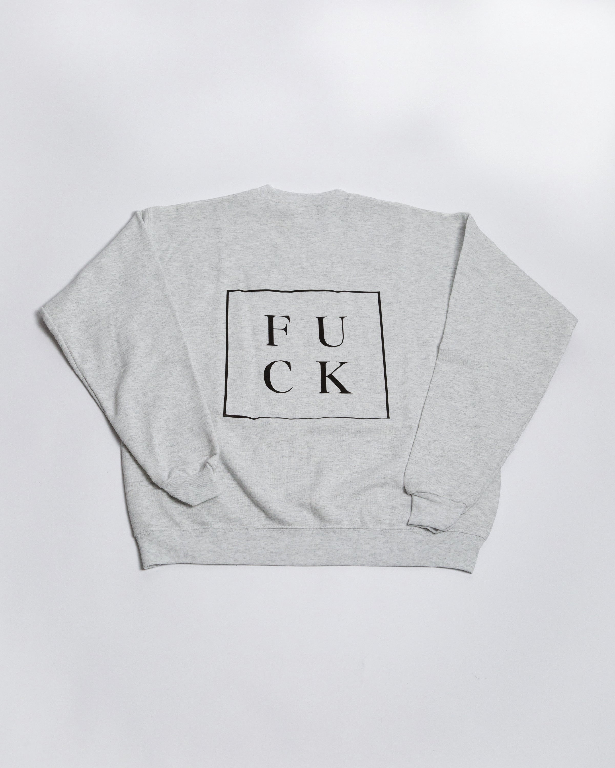 Detail view of the boxed F U C K graphic on a heather-gray crewneck.