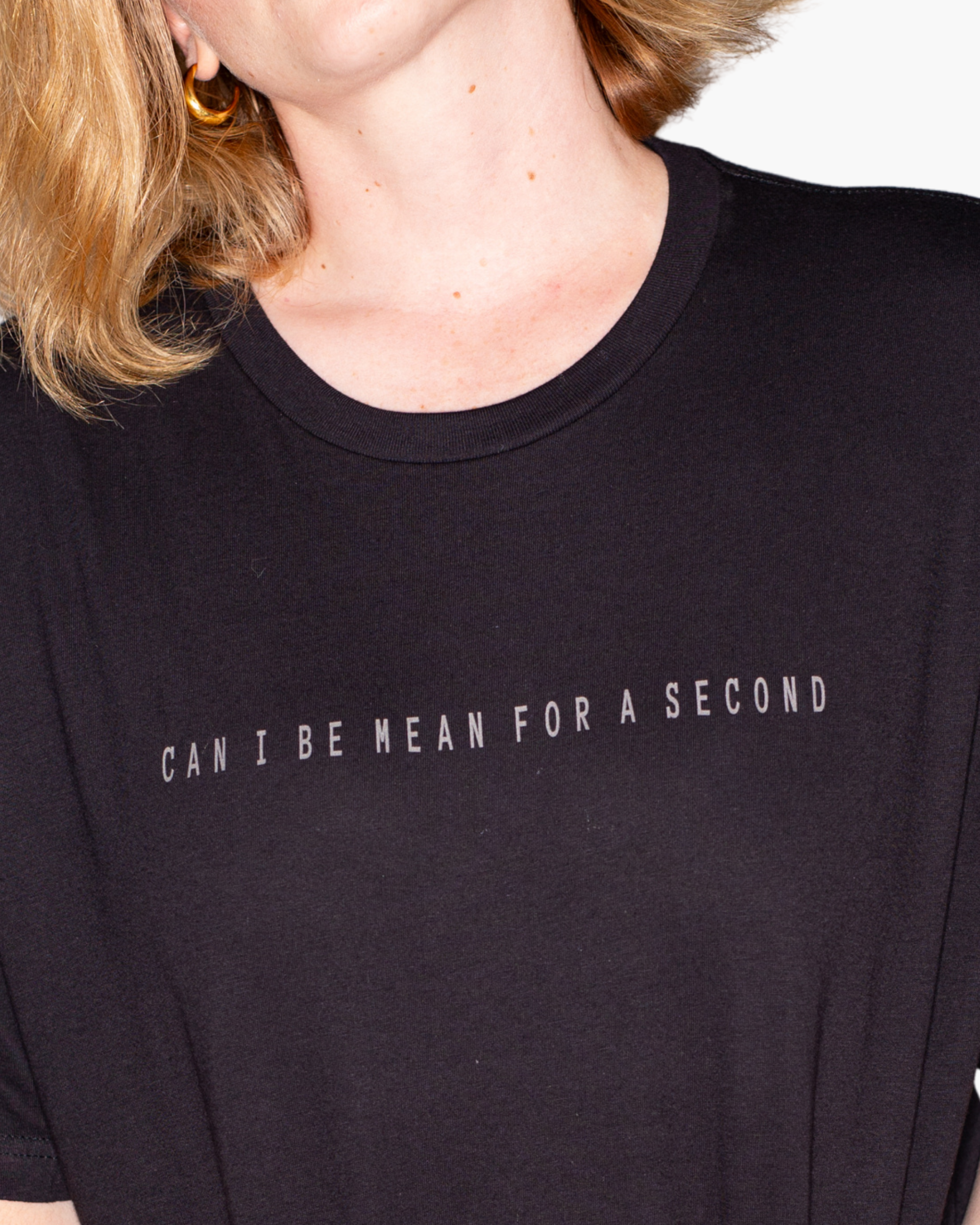Black crewneck T-shirt with subtle gray text reading CAN I BE MEAN FOR A SECOND.