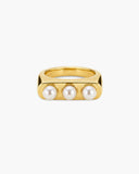 Chunky gold-tone Cilla ring with three round white pearl-like accents on a white background.