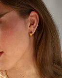 Cleo ridged gold huggie worn close to the ear.
