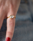 Davina east-west pear-cut ring worn with a long red nail in a tight finger detail against dark denim.
