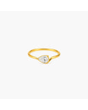Gold-tone Davina ring with a horizontally set pear-shaped clear stone and sculptural tapered band on a white background.