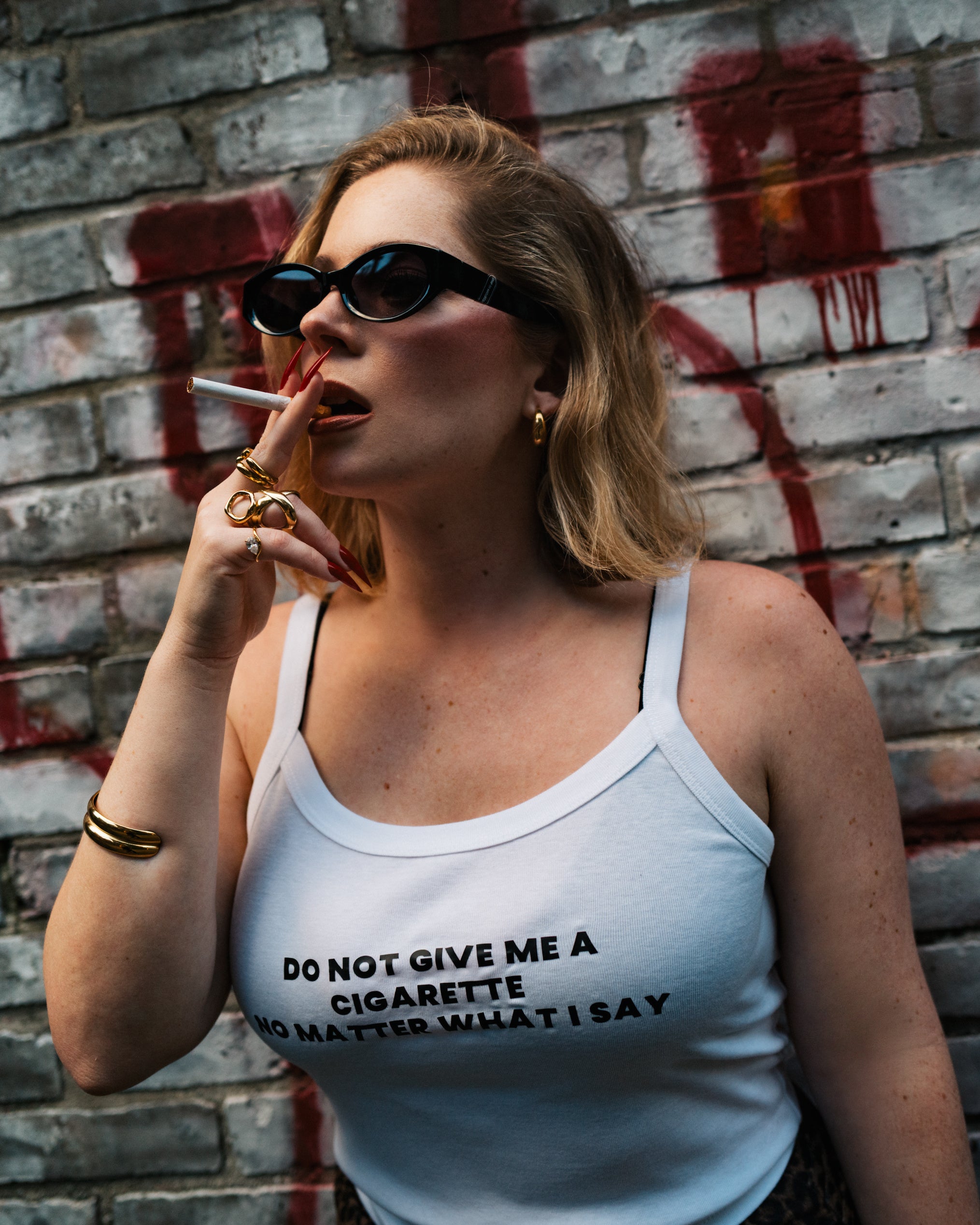 Lifestyle view of the white Do Not Give Me a Cigarette camisole tank.