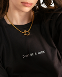 Black crewneck T-shirt with small white text centered on the chest reading DON’T BE A DICK.