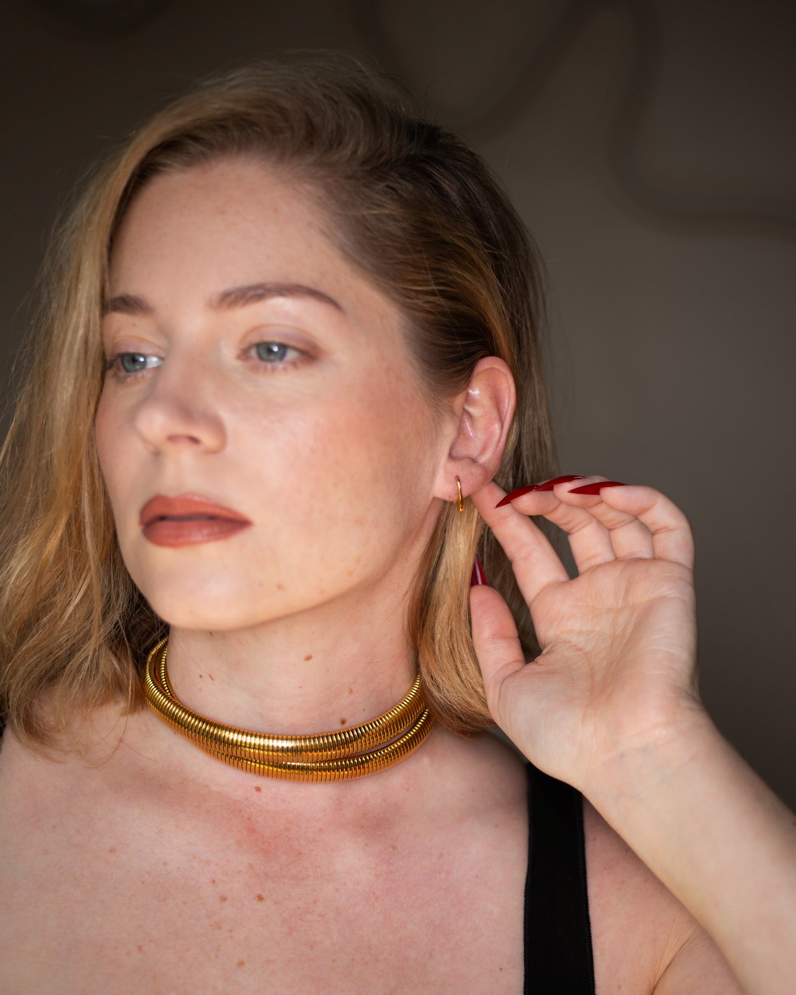 Dori gold threader earring styled in a clean close-up portrait.