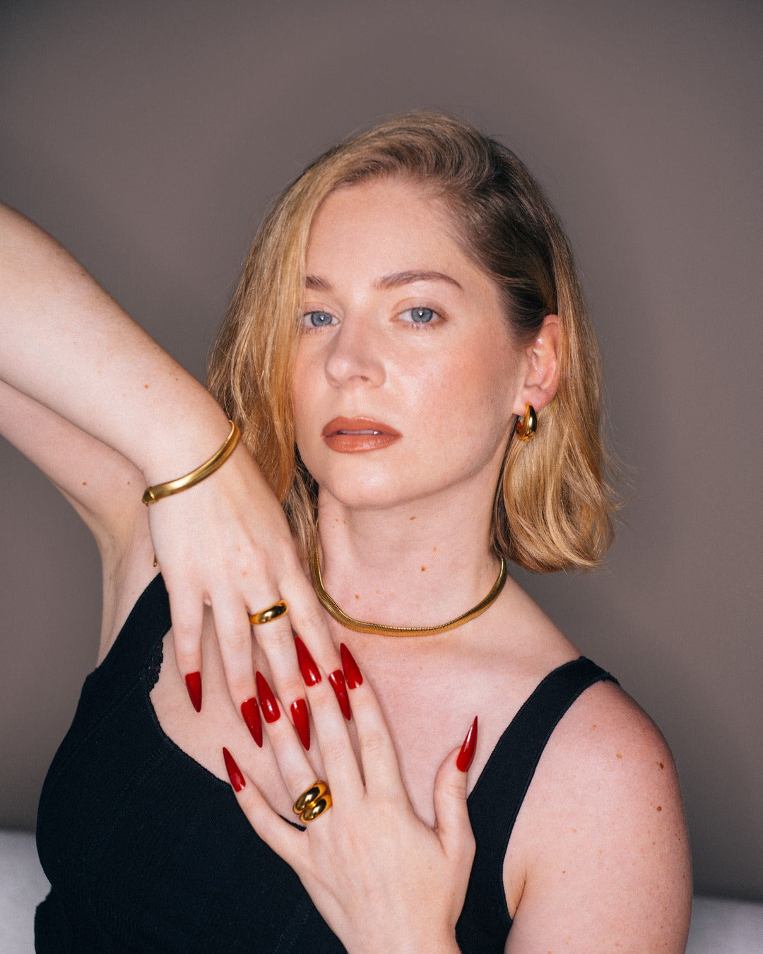 Elle Chain worn in a styled portrait with stacked gold jewelry.