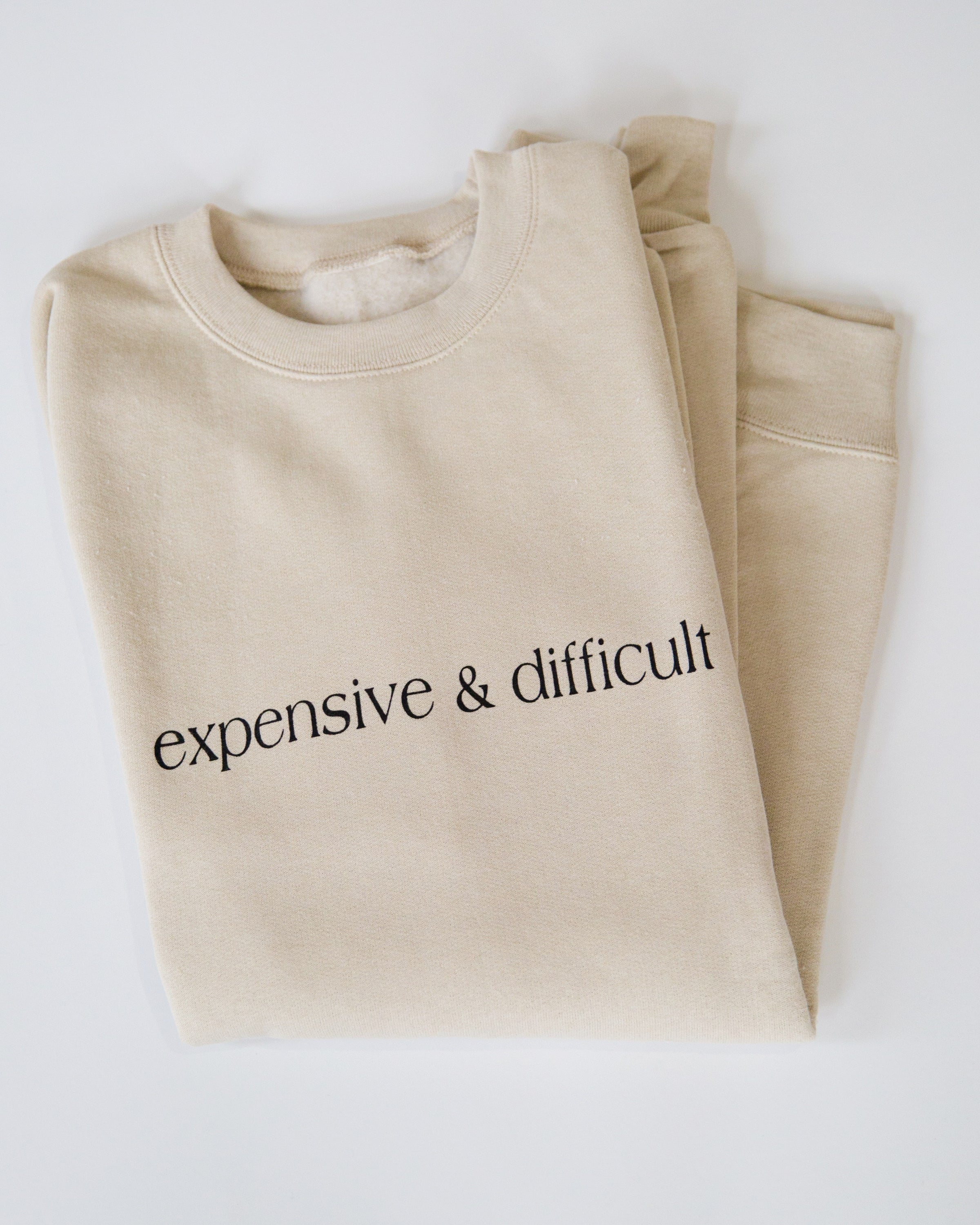 Folded cream Expensive & Difficult crewneck sweatshirt.