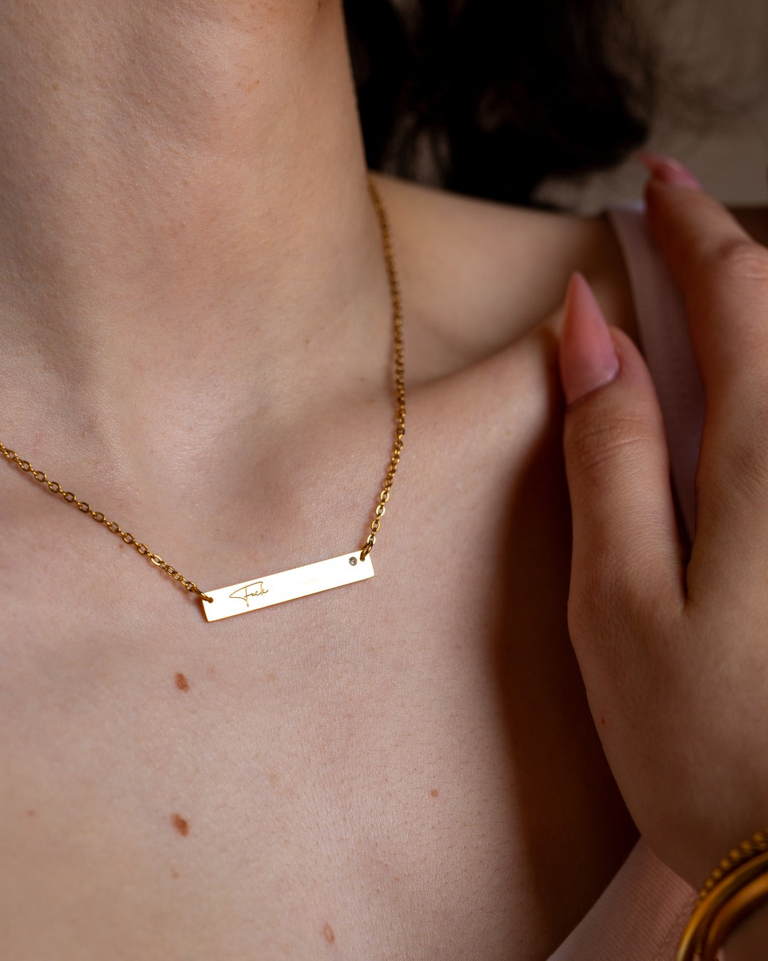 Fuck Bar Necklace shown in a close styled neckline view.