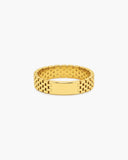 Wide polished gold-tone Harmonia ring with watchband-inspired brick links and a smooth rectangular center plate on a white background.