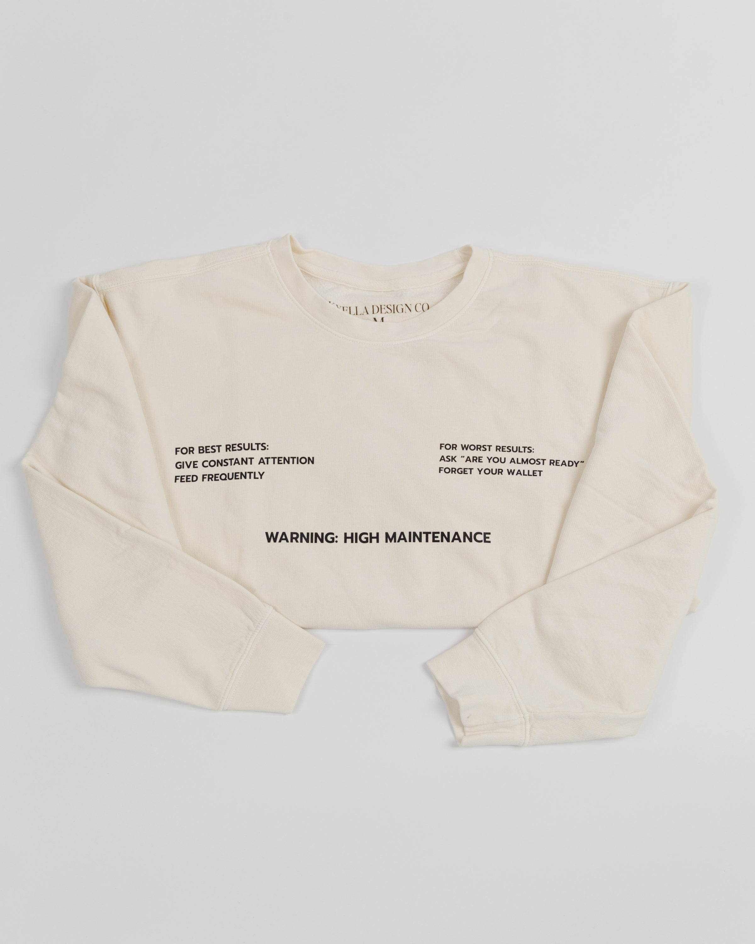 Cream High Maintenance crewneck sweatshirt worn by a model.