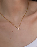 Gold initial K necklace worn at the neckline, hover view.
