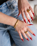 Isadora bracelet styled with gold rings and red nails