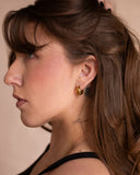 Jackie tapered dome gold huggie worn in a side portrait.
