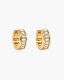 Pair of wide gold-tone huggie hoop earrings lined with clear baguette-cut stones.