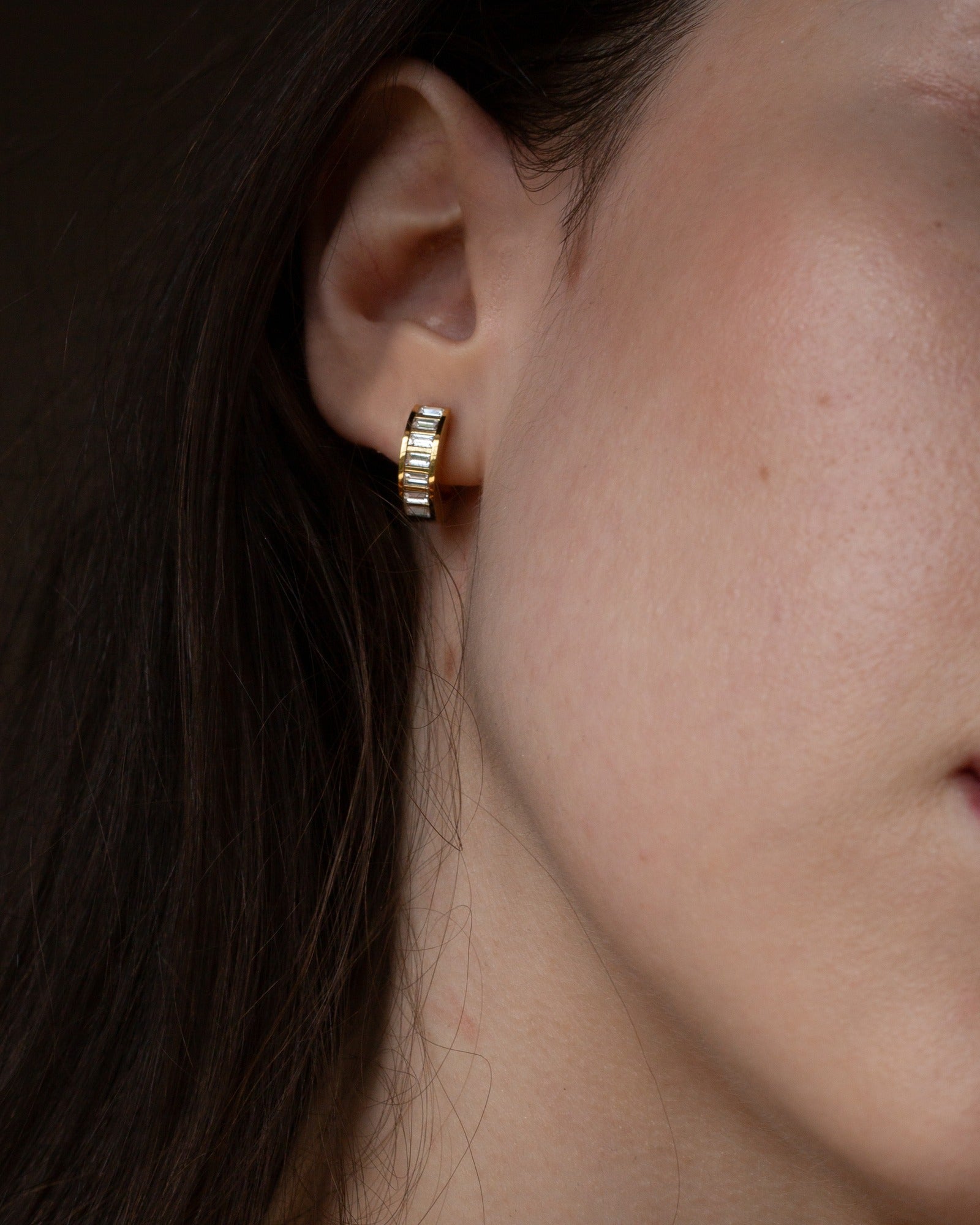 Josephine gold baguette huggie shown in a tight ear detail.