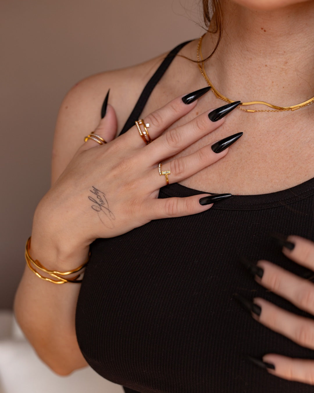 Leda Chain worn in a styled lifestyle view with stacked gold jewelry.