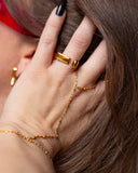 Lisbeth asymmetrical sculptural gold earring shown in a tight ear detail.