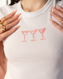 White baby tee with three red martini glass graphics.