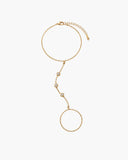 Morrigan hand chain, a gold-tone hand chain bracelet with three clear round stones, an adjustable wrist chain and a delicate finger-ring loop.