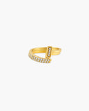 Gold-tone Noor open bypass ring with two offset rows of clear round stones on a white background.