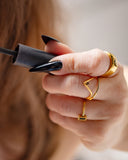 Nyx black pavé stacking ring worn with long black nails while holding a mascara wand.