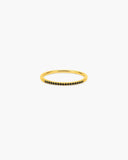 Slim gold-tone Nyx stacking ring with a front row of small black pavé-style stones on a white background.