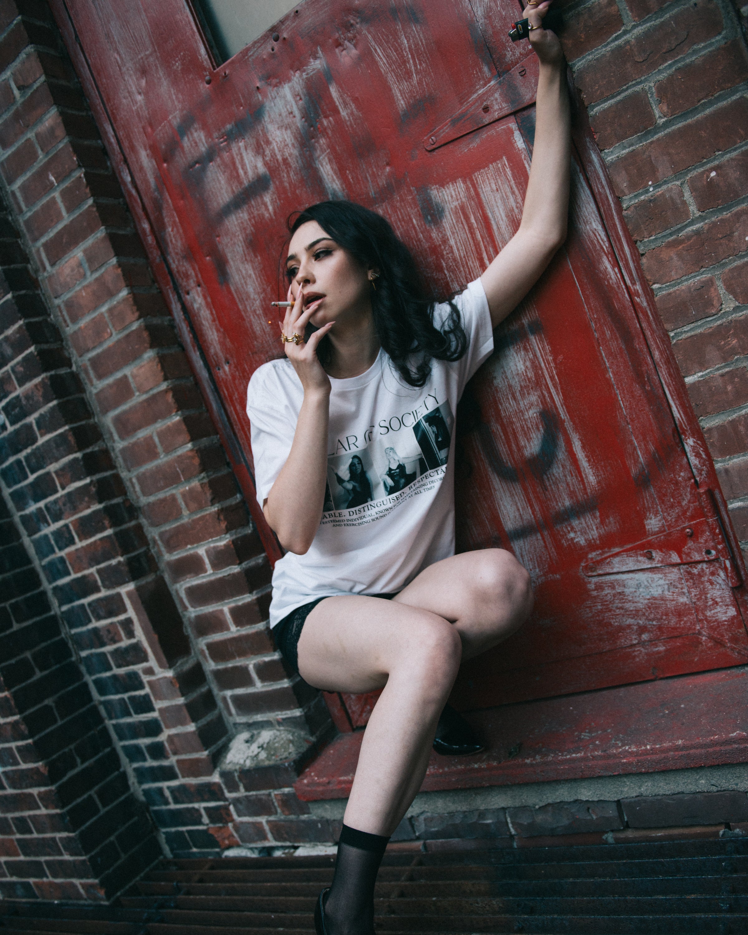 Lifestyle view of the white Pillar of Society graphic T-shirt.