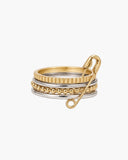 Prue mixed-metal stacked ring with geometric bands and an oversized gold safety-pin accent on a white background.