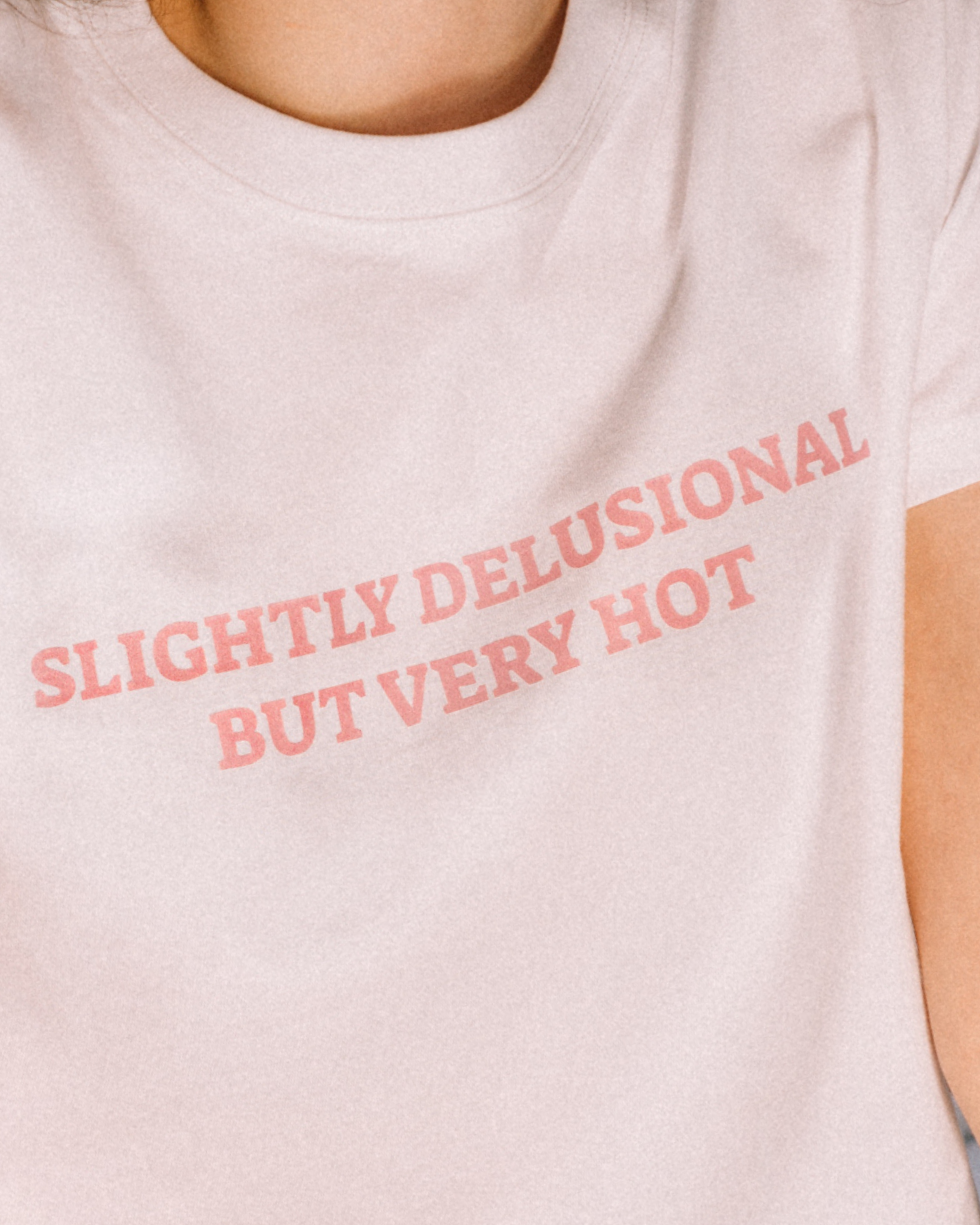 White cropped tee reading Slightly Delusional But Very Hot.