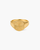 Polished gold-tone Sol signet ring with a round engraved sunburst face on a white background.