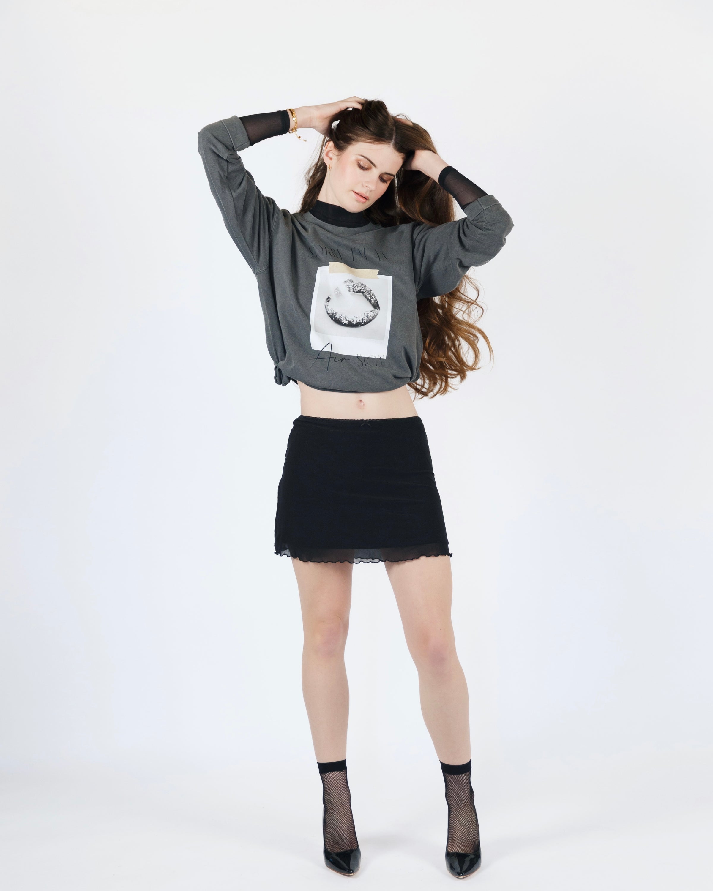 Full-body model view of the washed charcoal Sorry I’m an Air Sign crewneck sweatshirt.