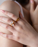 Talia two-stone crossover ring worn with pale pink nails in a close shoulder detail.