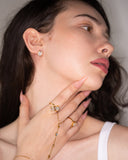 Trinity rectangular crystal stud worn in a close portrait.