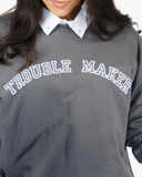 Charcoal crewneck sweatshirt with white collegiate text reading Trouble Maker.