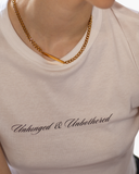 White baby tee with Unhinged & Unbothered script.