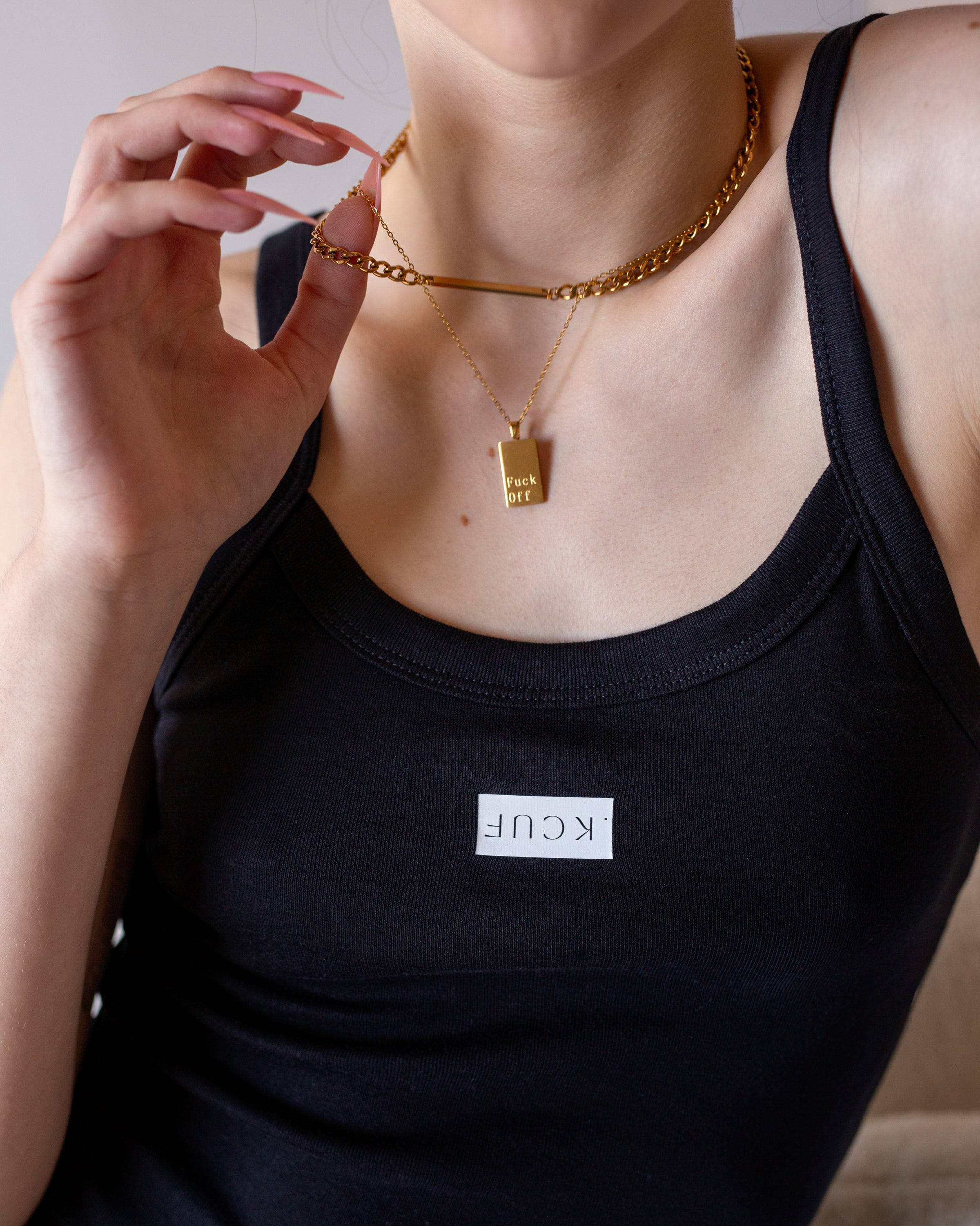 Detail view of the inverted white Fuck graphic on the black camisole tank.