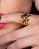 Vivi sculptural gold statement ring worn with long black nails in a close hand-to-lips portrait.