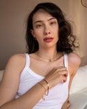 Gold zodiac necklace worn in a styled lifestyle portrait.